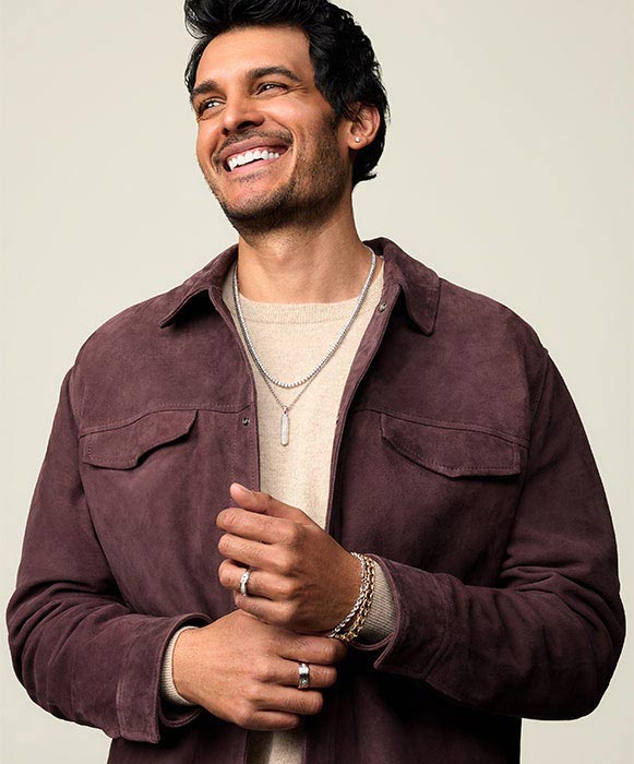 Smiling man wearing layered Blue Nile jewelry for Father’s Day gifts campaign.