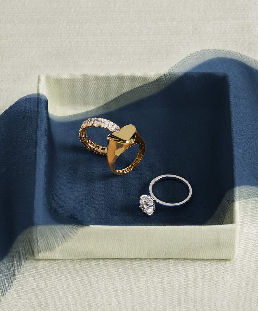 Gold and diamond rings showcased in a signature gift box with navy ribbon.