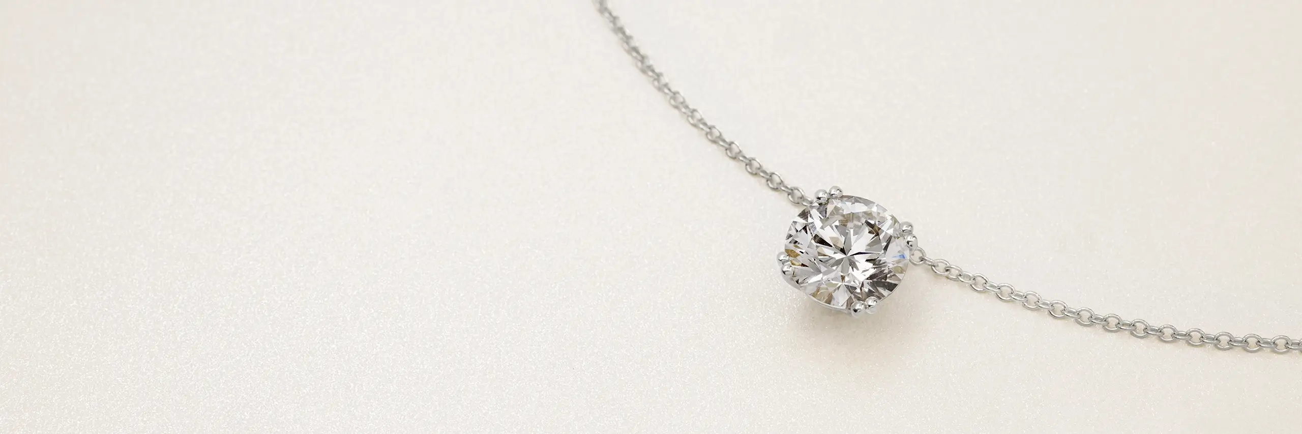 Diamond pendant necklace on a cable chain with a solitaire round diamond.